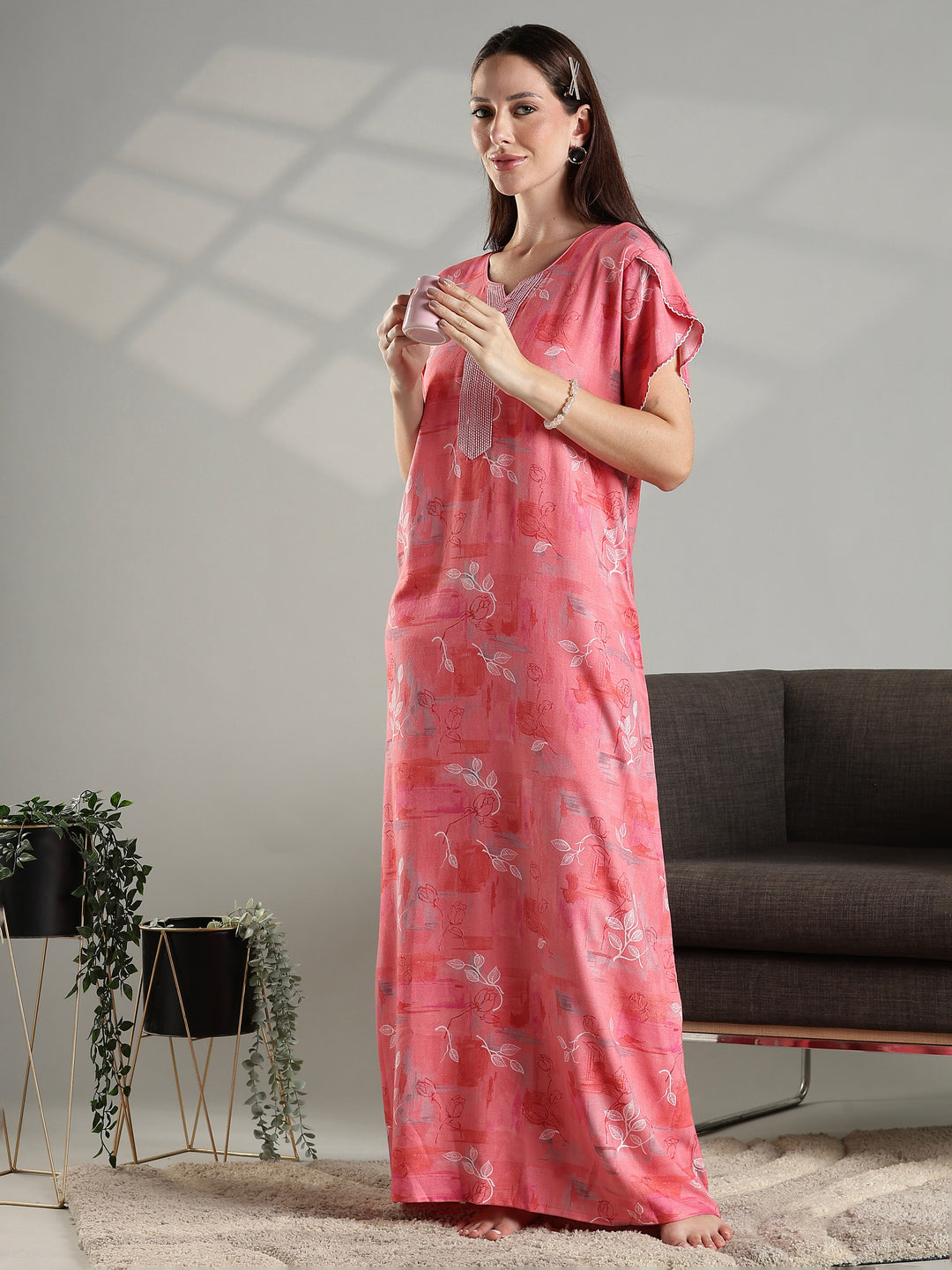 Woman wearing a pink nightgown in a living room setting